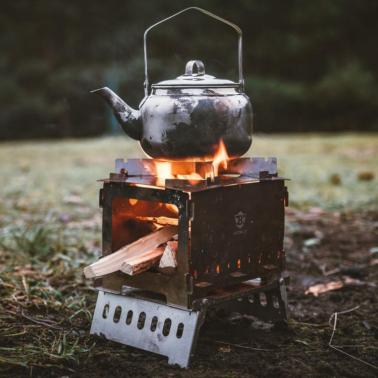 Verwenden Sie den Camping Holzofen Tragbar Hobo Kocher, um das Wasser im Wasserkocher zum Kochen zu bringen